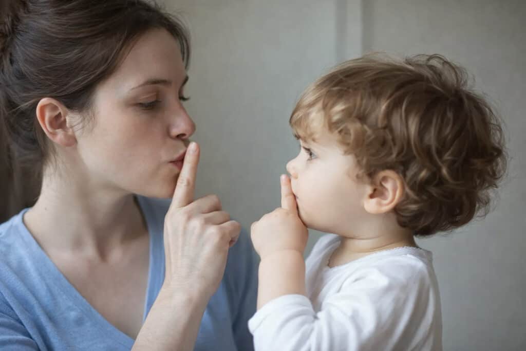 An anxious mother on the phone while her child watches, showing how children observe and learn anxious behaviour